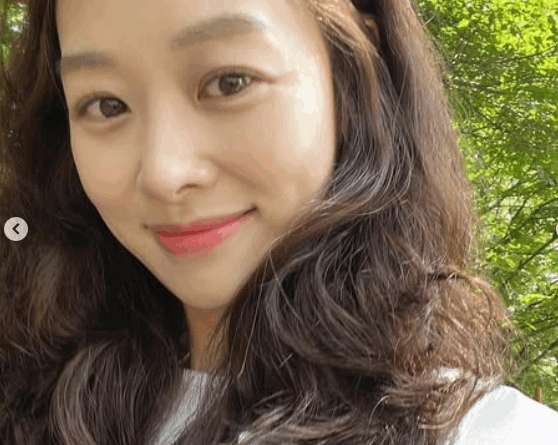 Jang Shinyoung smiles in a sunny park photo shared after public controversy