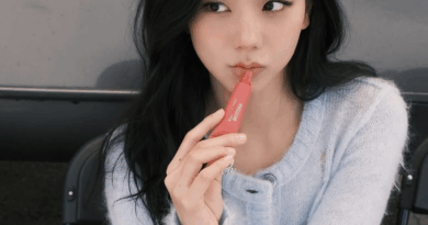 BLACKPINK Jisoo wears knit sweater while applying lip gloss under natural light