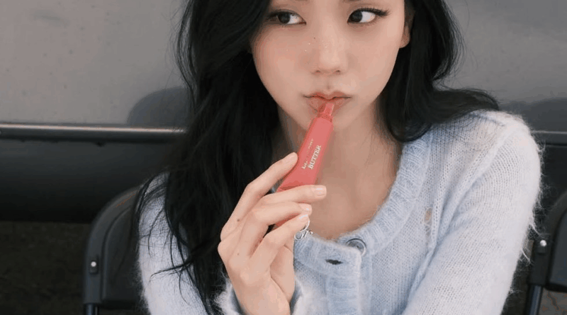 BLACKPINK Jisoo wears knit sweater while applying lip gloss under natural light